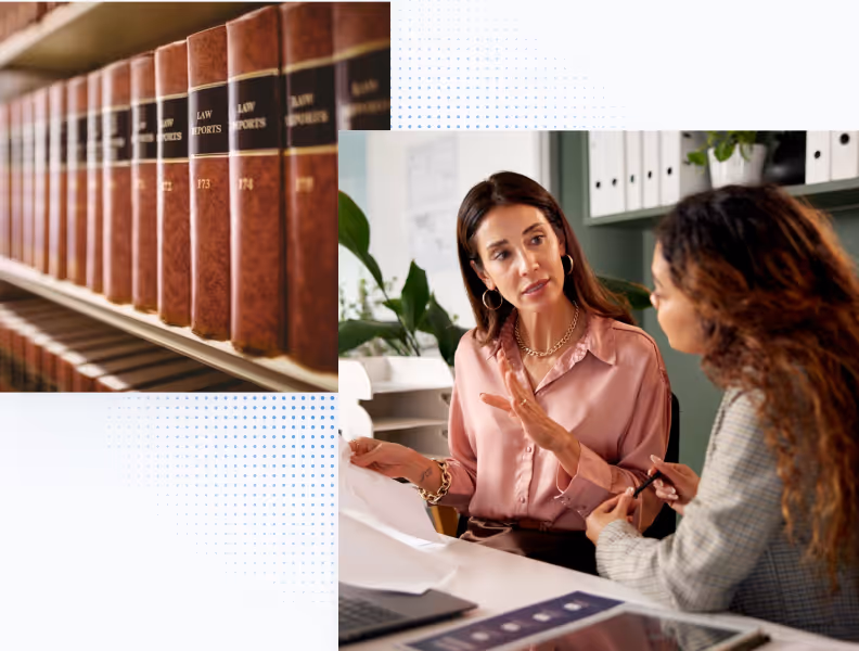Two women discussing documents in an office with legal books on a nearby shelf.