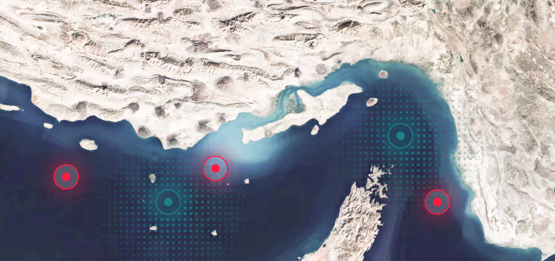 Satellite view of a coastal area with land, sea, islands, and red and teal target markers on the water.