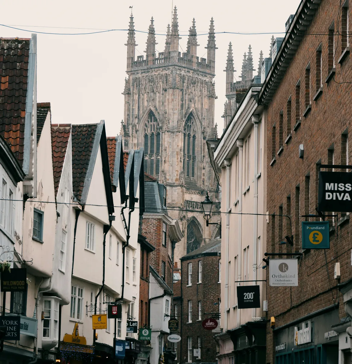 Shops and businesses on Low Petergate in York city centre, with York Minster rising behind