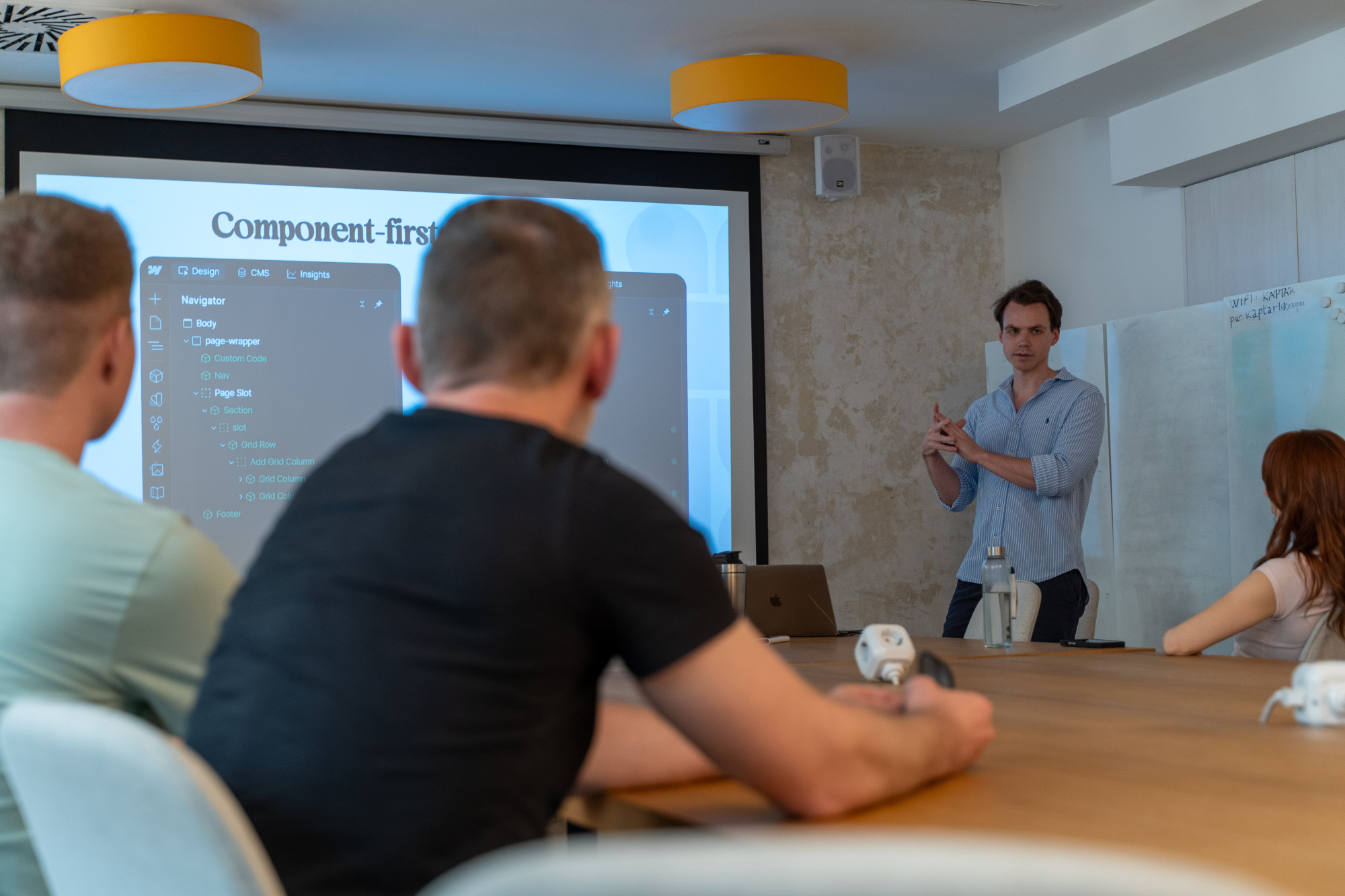 Nicholas presenting while people are listening to him.