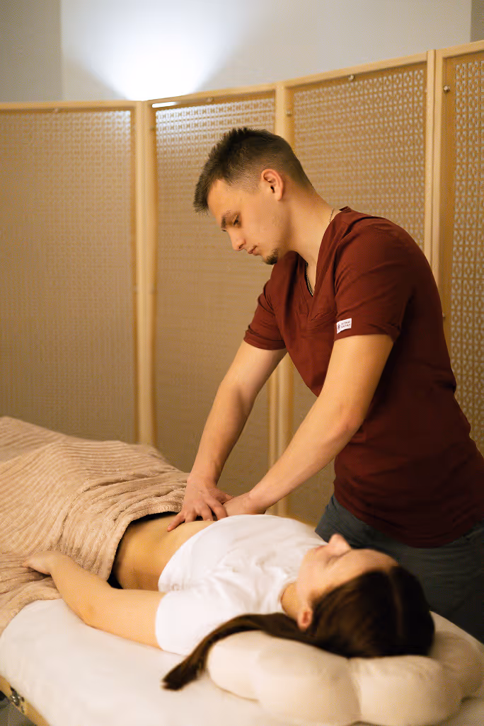 Чоловік робить масаж живота