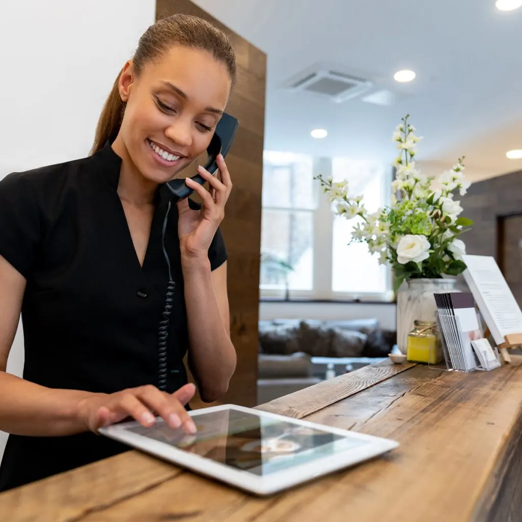 A vacation rental manager takes a phone call from a guest.