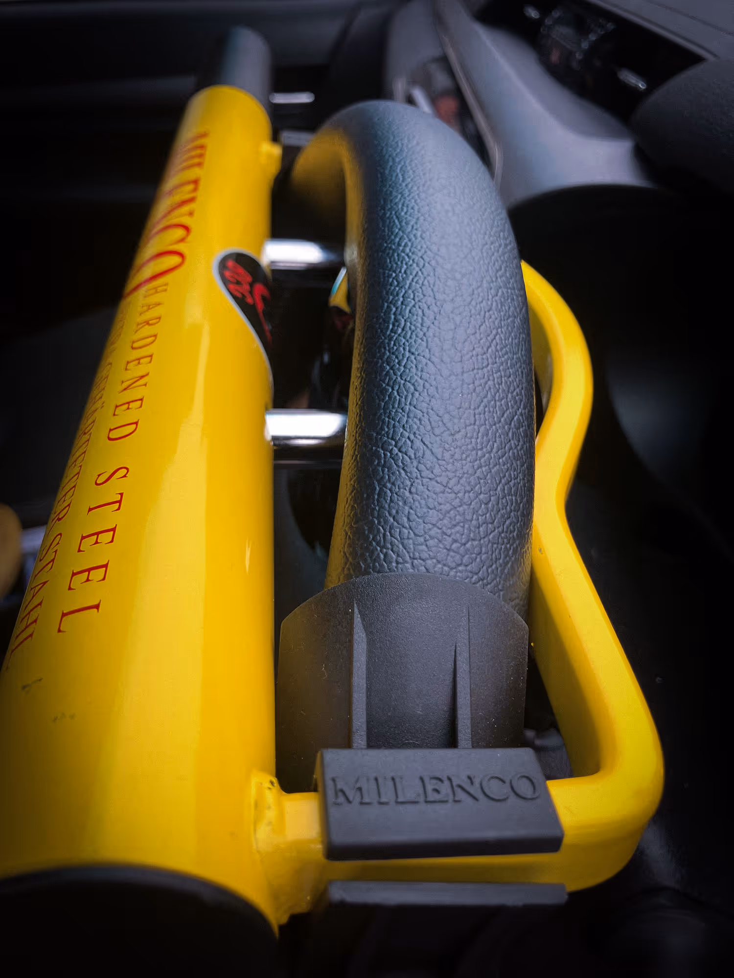 Sunset view of Dubai skyline with Burj Khalifa in the center, silhouetted palm trees, and walkway with street lamps.