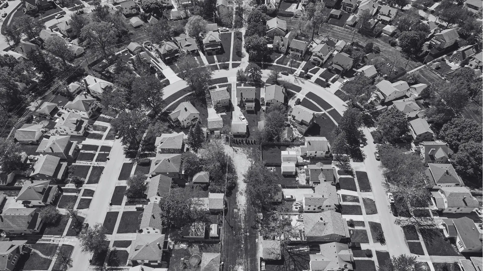 Black and white aerial view of a Midwest Ohio neighborhood showing houses, streets, and trees arranged in a curved street layout.