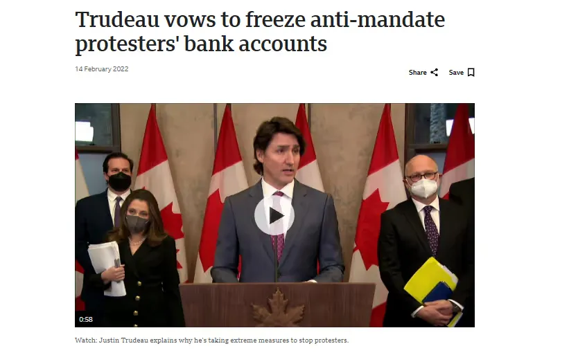 Justin Trudeau speaking at a podium with Canadian flags behind him and four masked officials standing nearby.