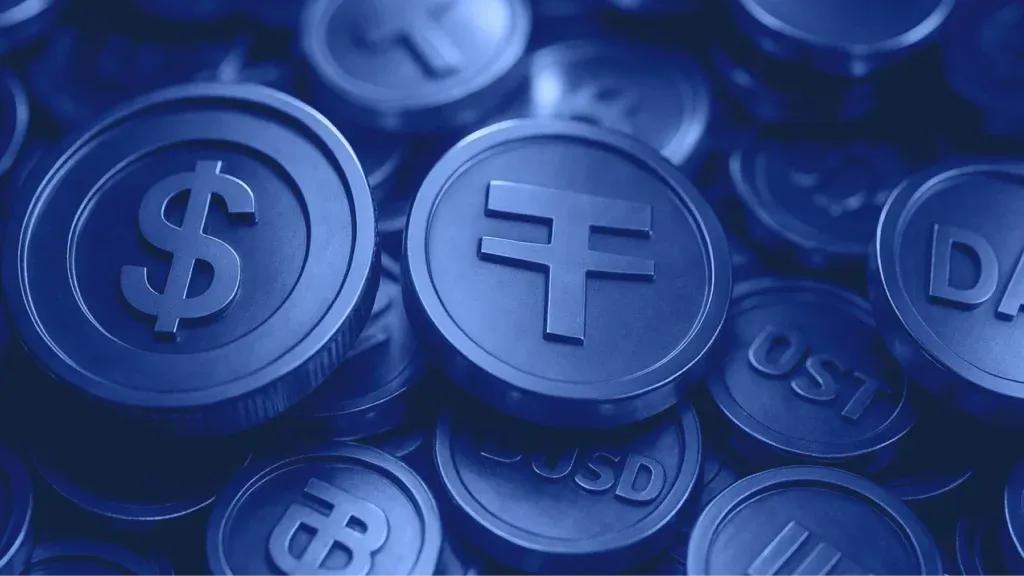 Stack of blue-toned coins with embossed cryptocurrency symbols including dollar sign, USDT, and DAI.
