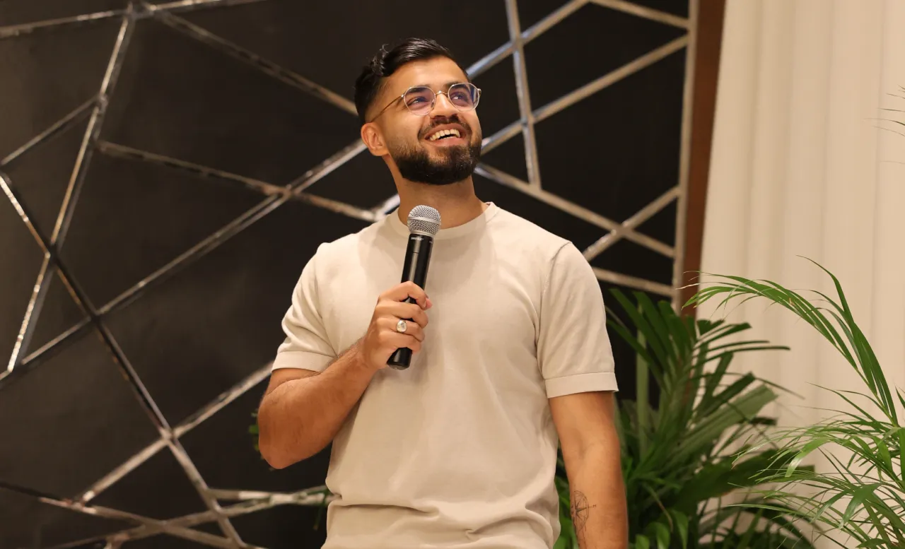 Tan holding mic while giving a speech