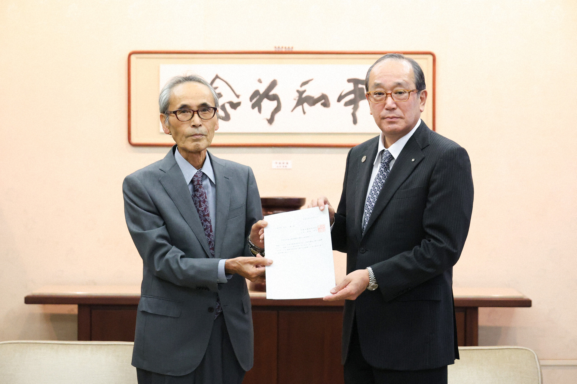 福島会長（左）が松井市長に意見書を手渡した