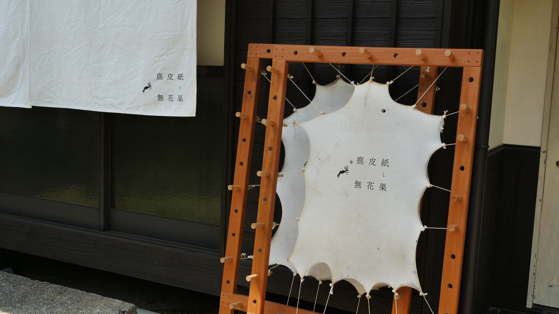 引っ張って乾燥させた鹿皮紙を、ショールームの看板に利用