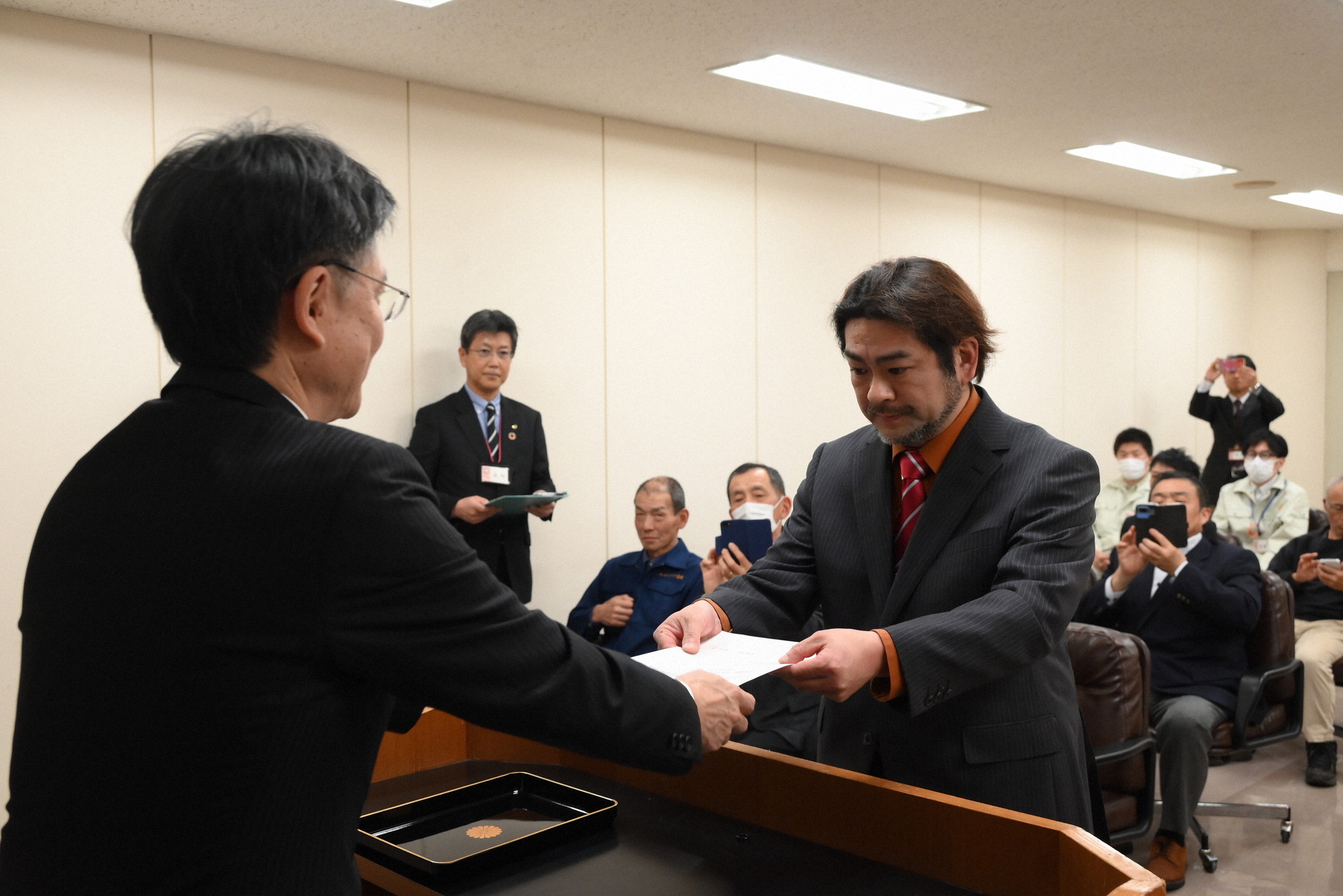 稲田市長（左）から任命書を受ける鈴木さん