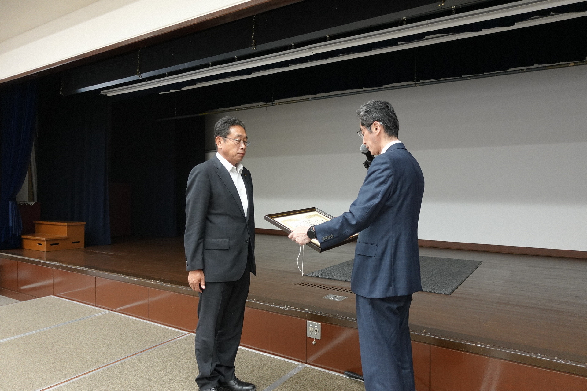黒田理事長から表彰を受ける、音更町農委会の茂古沼美則会長職務代理(左)