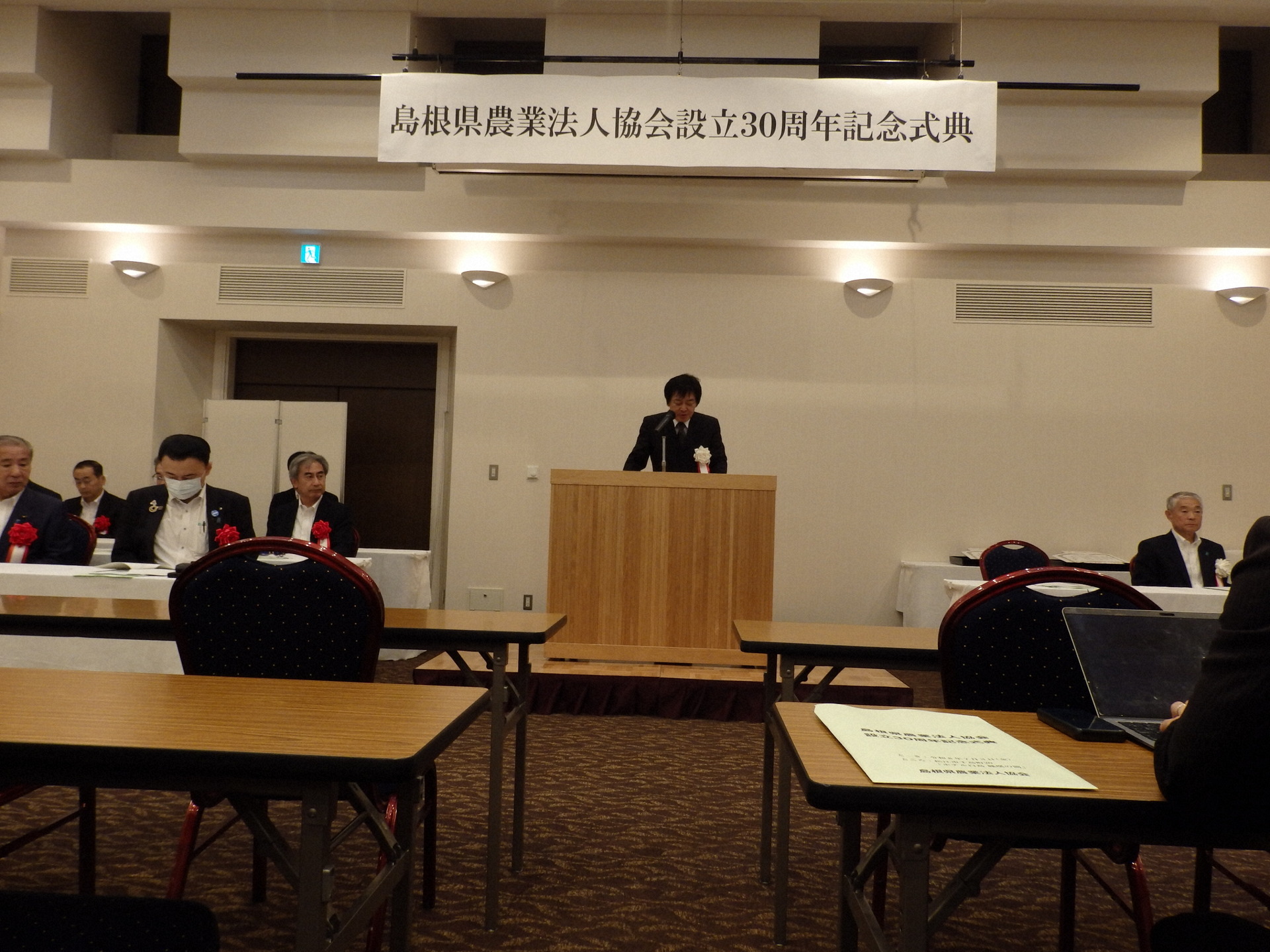 あいさつする吉岡会長