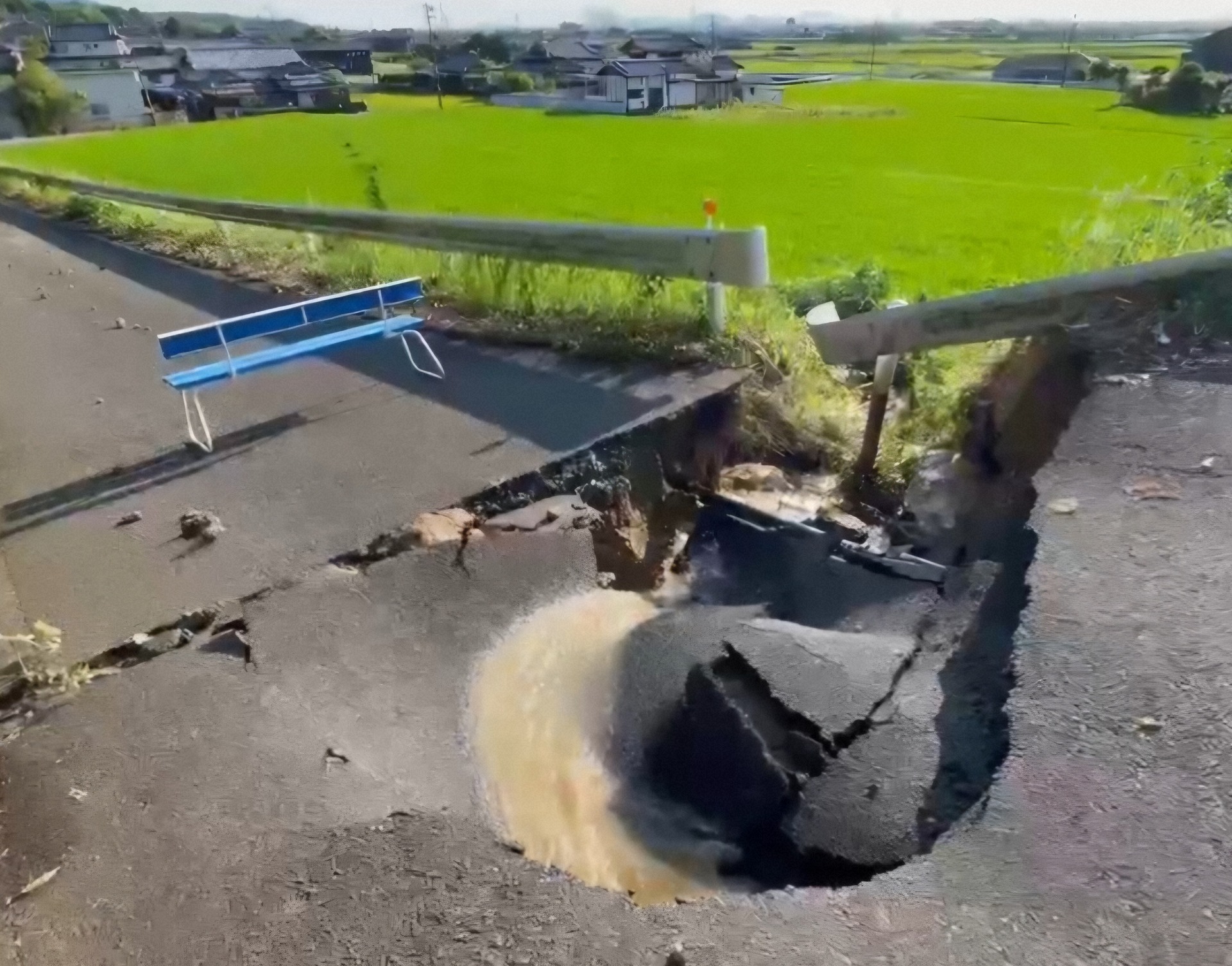 宇城市小川町南小野で道路陥没時に、ため池からの水路が損壊。奥の農地には地震による断層が現れた(写真提供・宇城市)