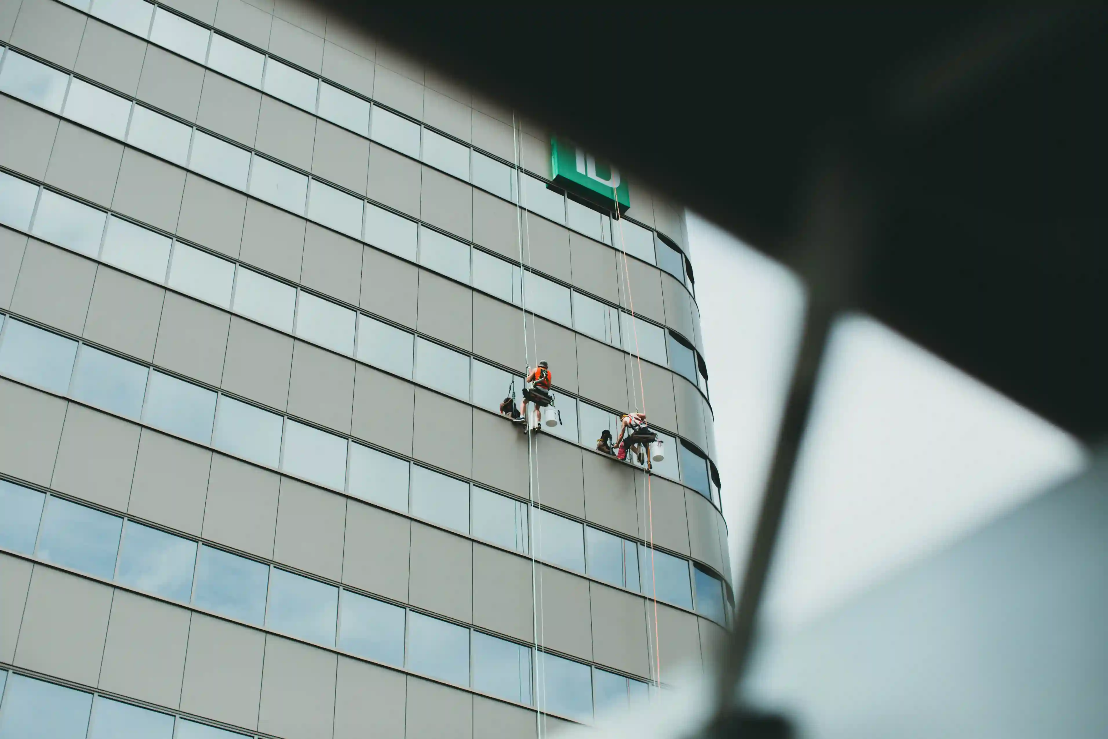 Professional workers performing high-rise building façade inspection, a common H3Zoom service application.