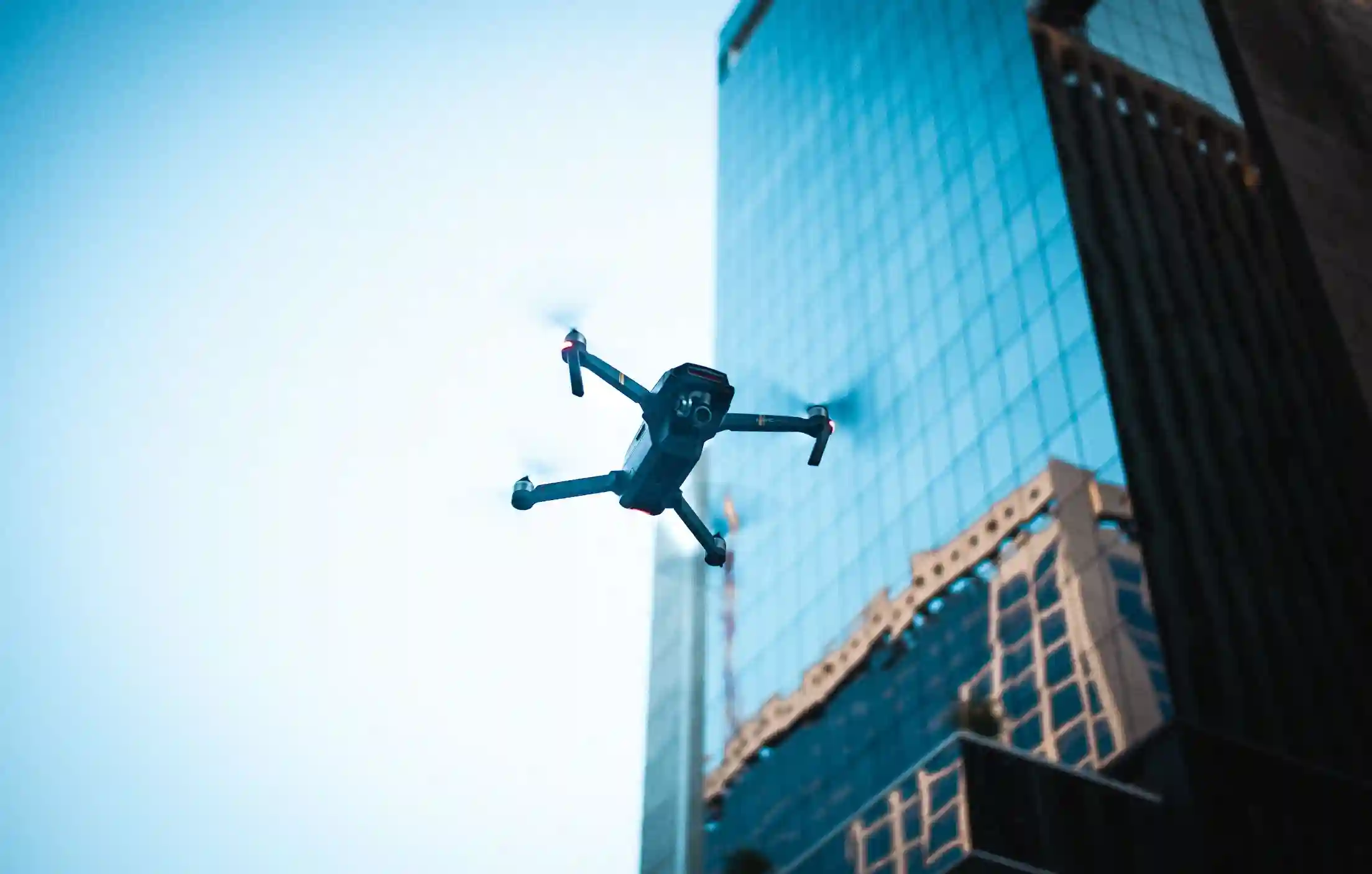 Aerial view of a H3Zoom drone inspecting a large-scale commercial building, highlighting efficient and safe exterior data capture for asset maintenance