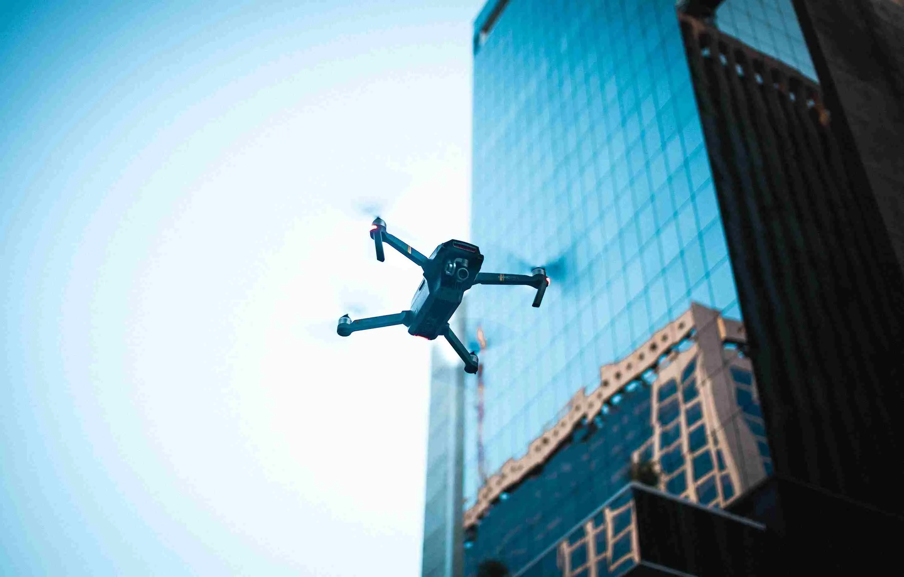 An inspection drone capturing aerial imagery of a high-rise commercial building for AI-powered structural analysis by h3zoom.ai.