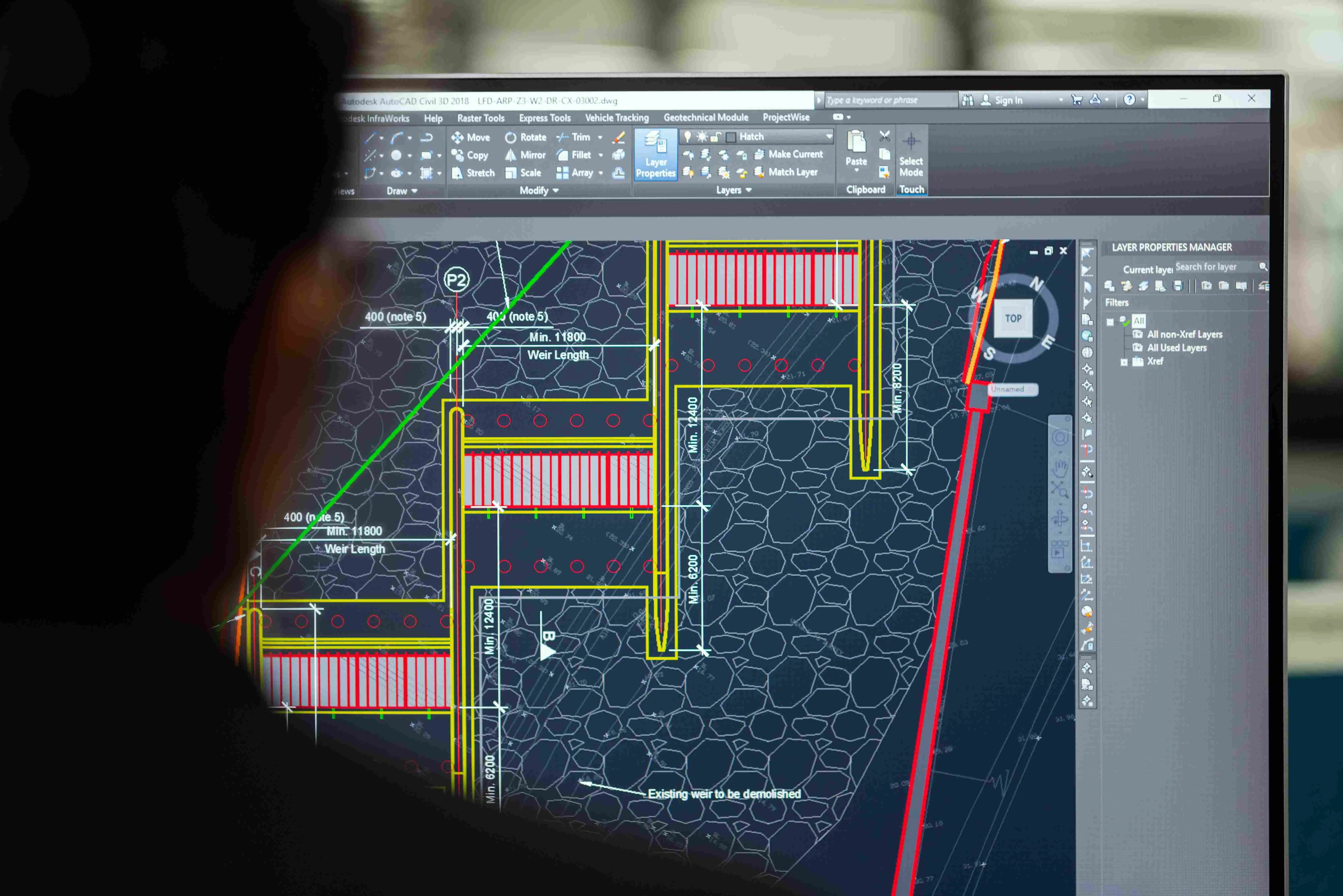 Close-up of a computer monitor displaying an engineering blueprint in Autodesk AutoCAD Civil 3D software, illustrating infrastructure design and enterprise AI applications in physical asset management.