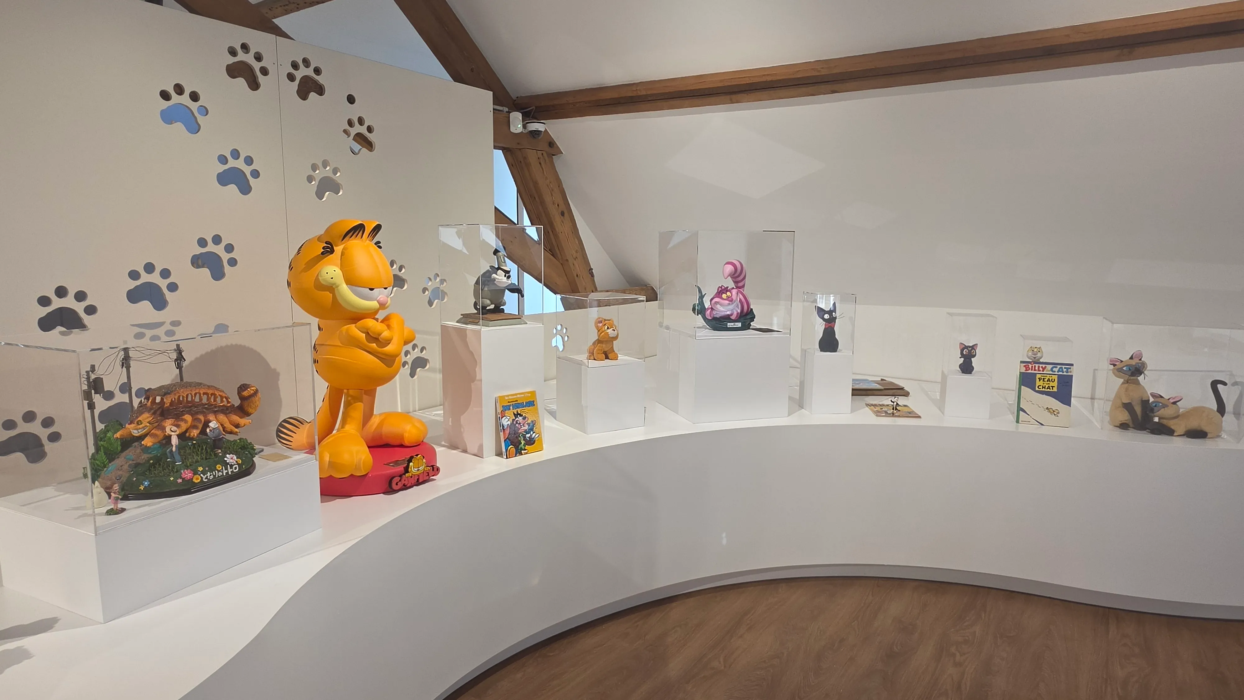 Vitrines de chats célèbres de la culture populaire, dont une grande statue de Garfield et le chat du Cheshire