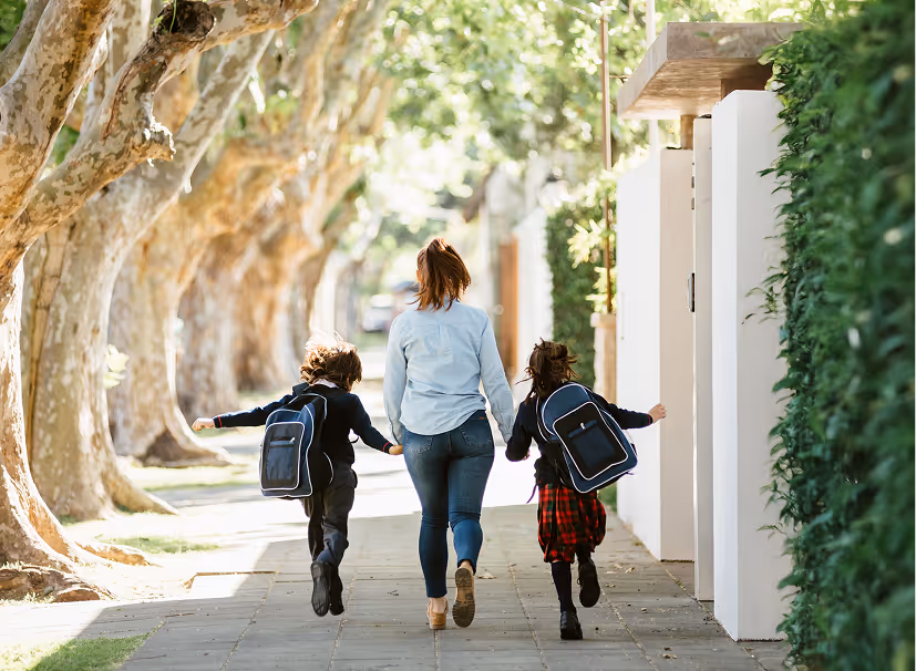 Three people sitting at a restaurant table enjoying a meal and laughing together.