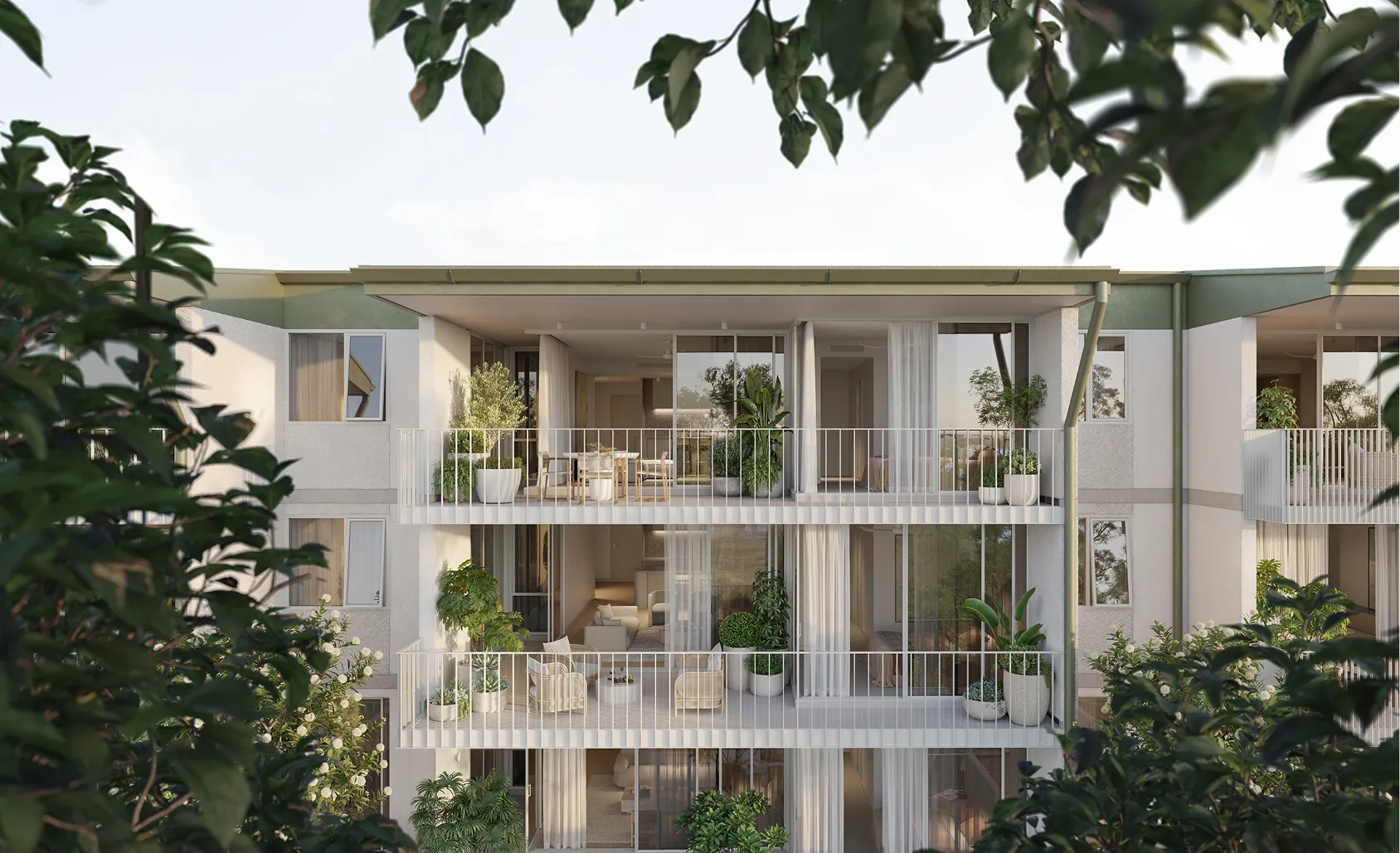 Modern three-story apartment building with glass balconies surrounded by lush greenery and palm trees.