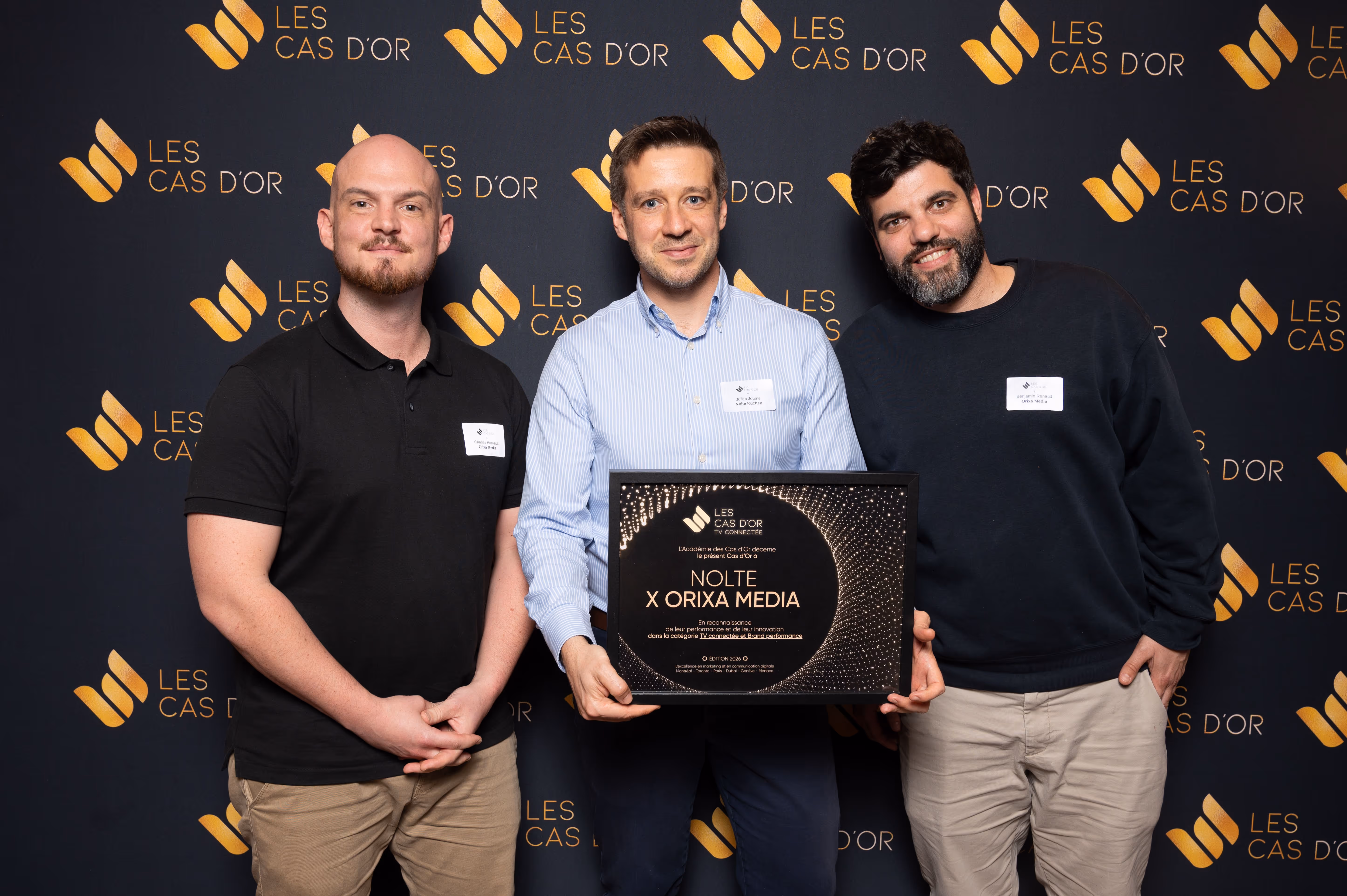 Trois personnes souriantes tenant un trophée de récompense Nolte Kuchen x Orixa pour performance Local.