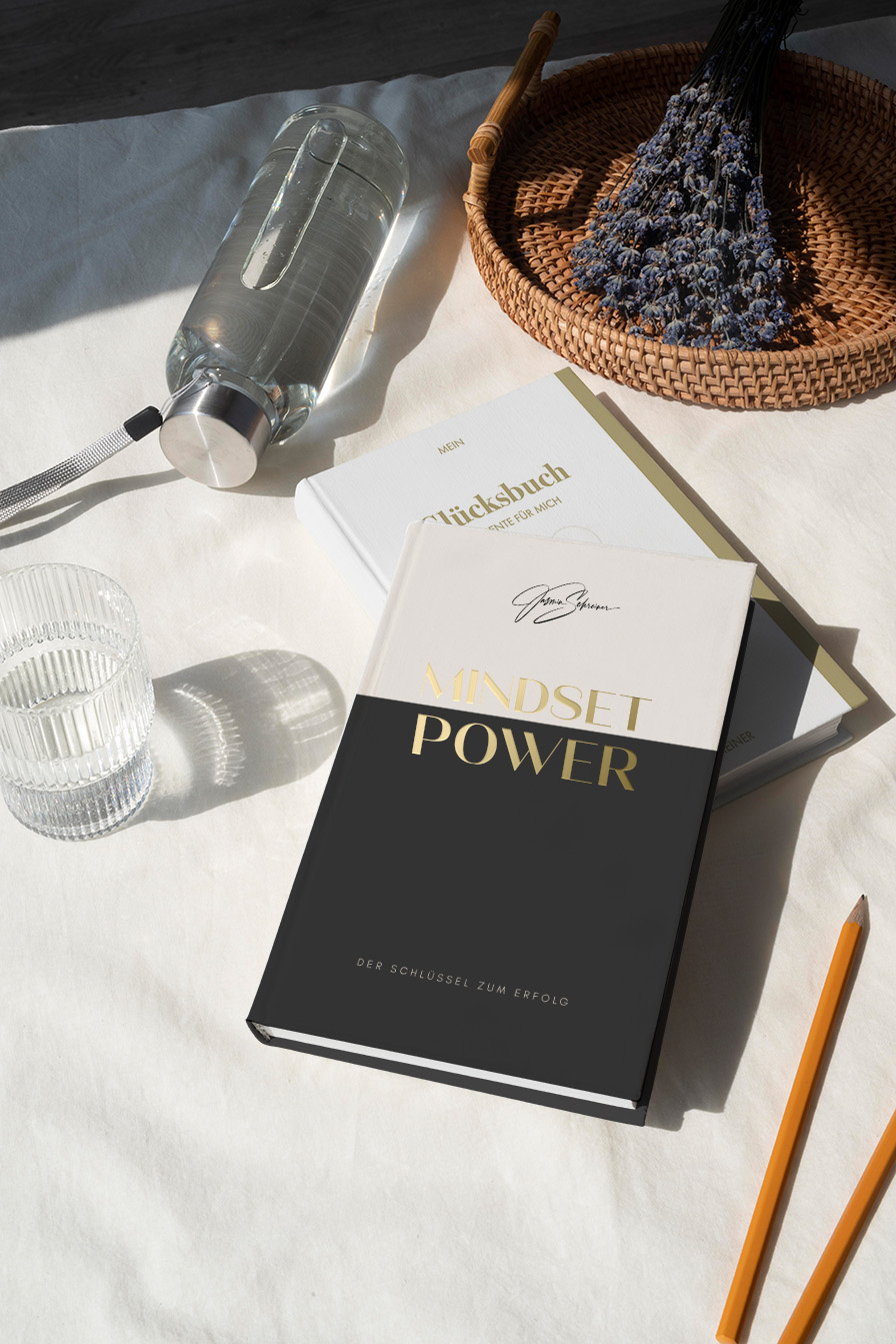 Smiling woman with shoulder-length brown hair sitting on a beige sofa while looking at her smartphone.