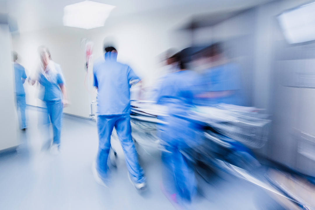 Hospital emergency department staff rushing a patient on a stretcher, representing serious sickle cell emergencies that require urgent hospital assessment and treatment.