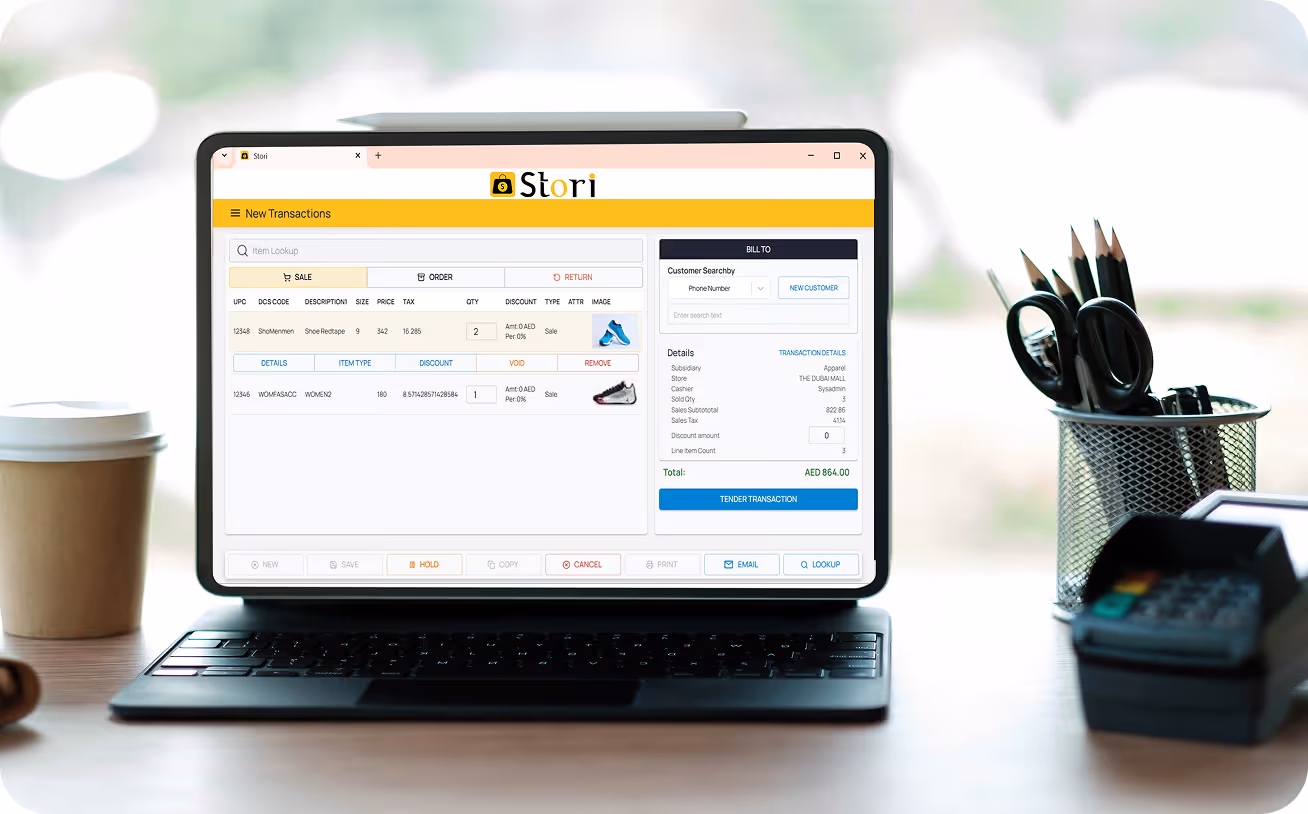Laptop on desk displaying Stori sales transaction software with item details and payment options.