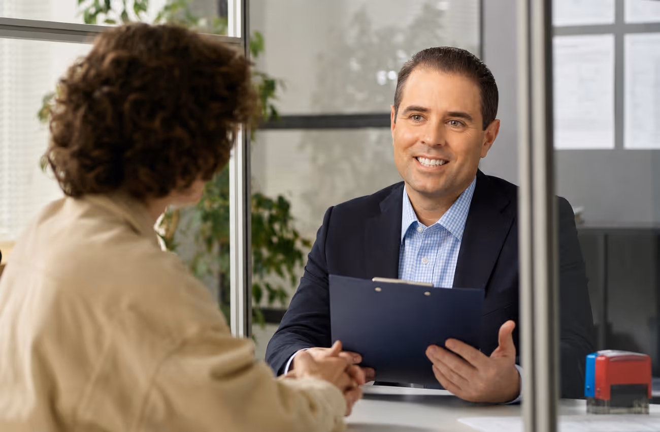 Timothy Doud meeting with a client in a modern insurance office, reviewing documents and discussing personalized coverage options.