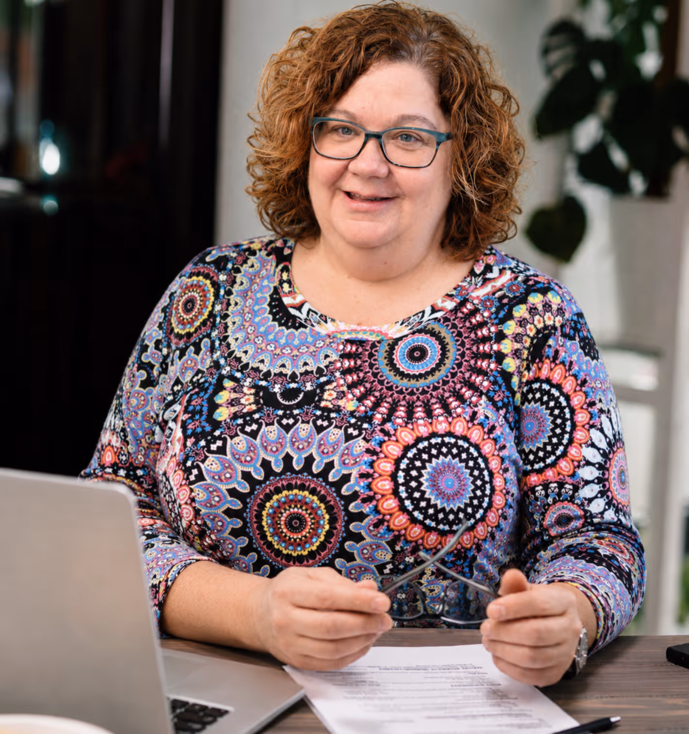 Sandy Inglehearn reviewing insurance documents at a desk in a professional office, providing friendly guidance for policy questions and claims support.