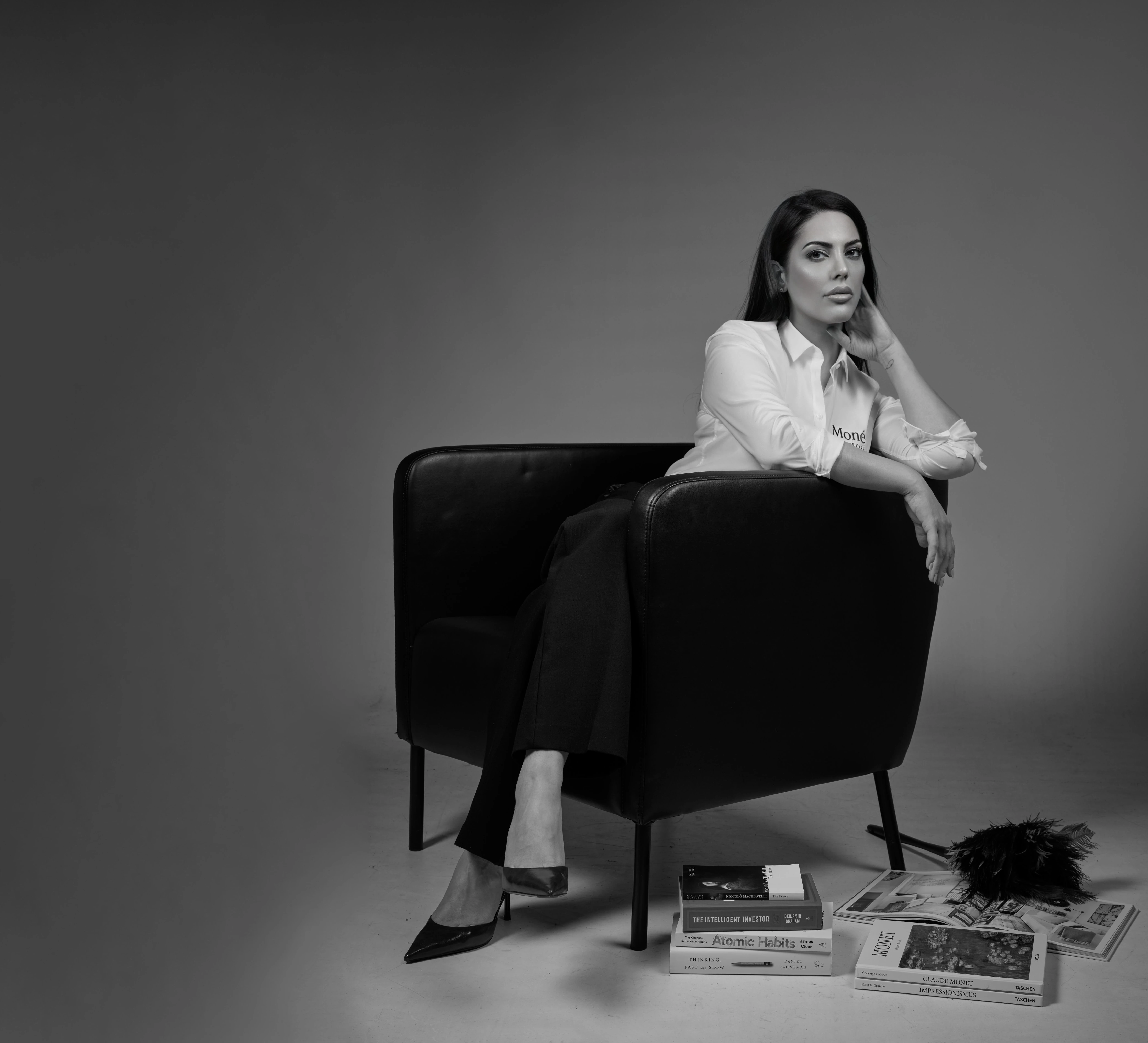 Porträt der Gründerin von MONÉ Business Care mit Sessel, Büchern und Gegenständen auf dem Boden