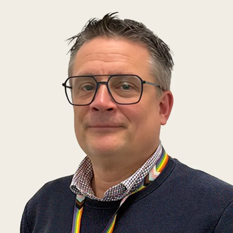 Porträtfoto von Markus Bielemeier, IKEA. Er trägt eine dunkle eckige Brille, 
einen marineblauen Pullover und ein kariertes Hemd. Um den Hals hängt 
ein Lanyard in Regenbogenfarben. Er lächelt leicht in die Kamera. 
Der Hintergrund ist hell und neutral.