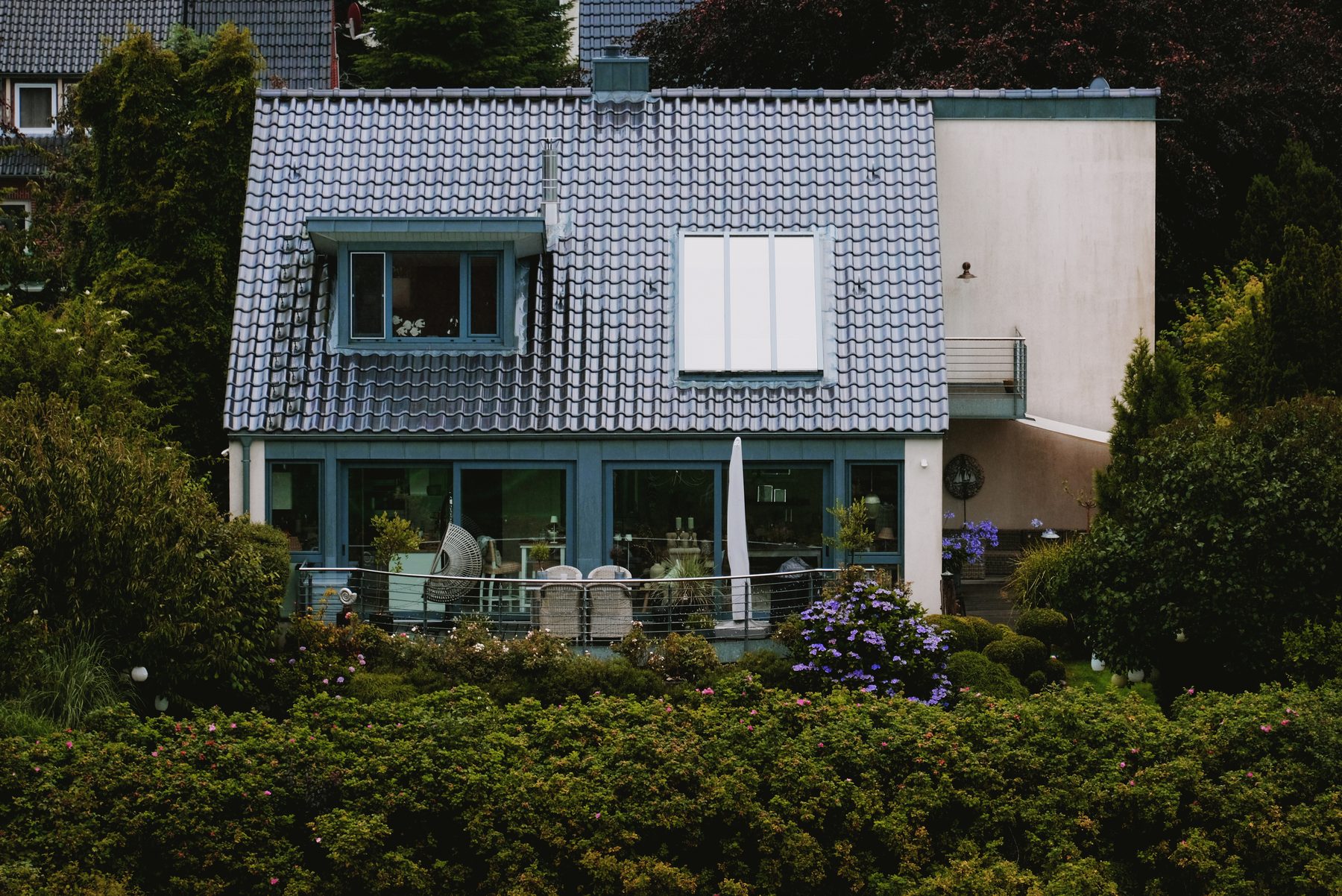 Einfamilienhaus mit gepflegtem Garten und Hecke in einer ruhigen Wohnstraße