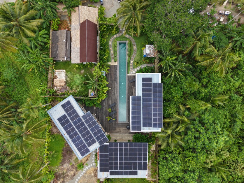 Vue aérienne par drone d'Islaya Villas à Siargao, menant en valeur les villas, la piscine et l'environnement tropical du complexe hôtelier.