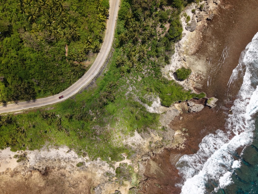 Vue aérienne par drone du littoral tropical de Siargao, aux Philippines, mettant en valeur la côte, les eaux turquoise et la végétation luxuriante.