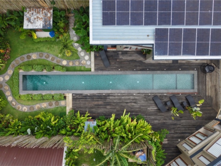 Vue aérienne par drone d'Islaya Villas à Siargao, mettant en valeur la piscine, les villas, les espaces extérieurs et l'architecture tropicale du complexe.