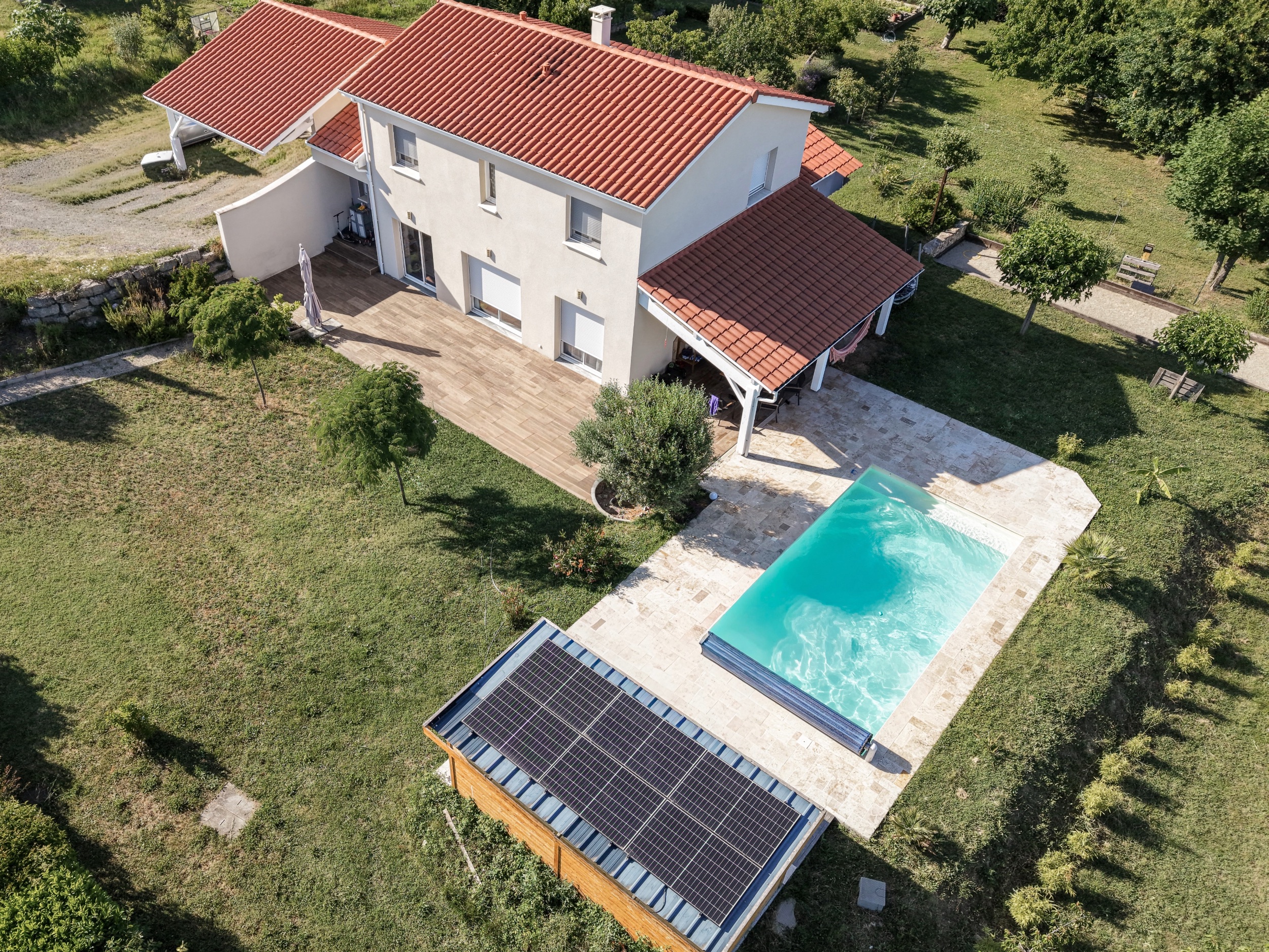 Vue aérienne mettant en valeur la maison, son jardin, sa piscine et ses aménagements extérieurs.