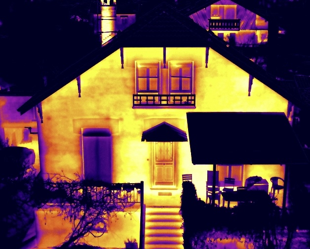 Image thermique aérienne d'un habitation individuelle mettant en évidence les variations de température sur la façade, les ouvertures et les éléments de toiture.