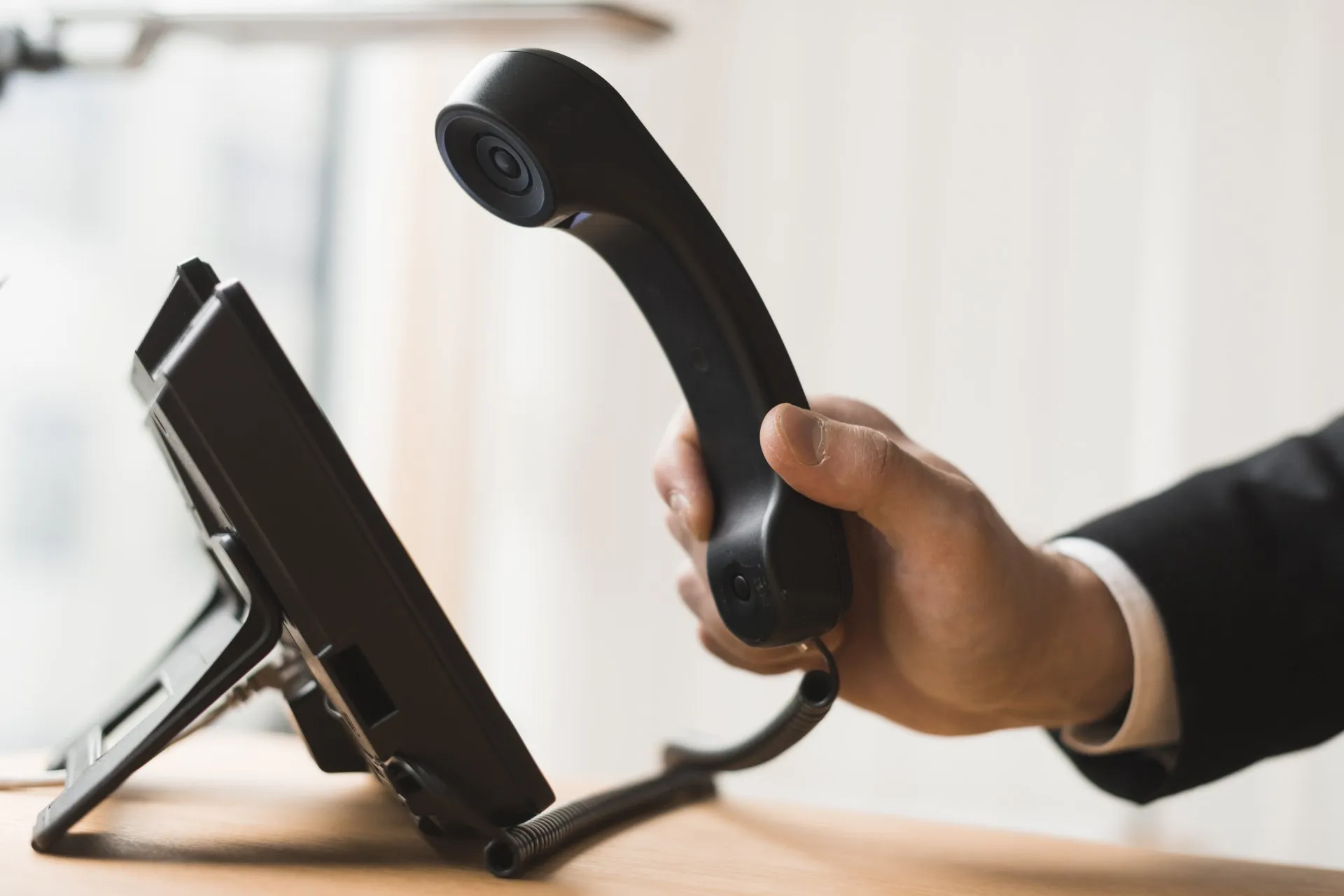 Hand picking up a phone for toll free calling