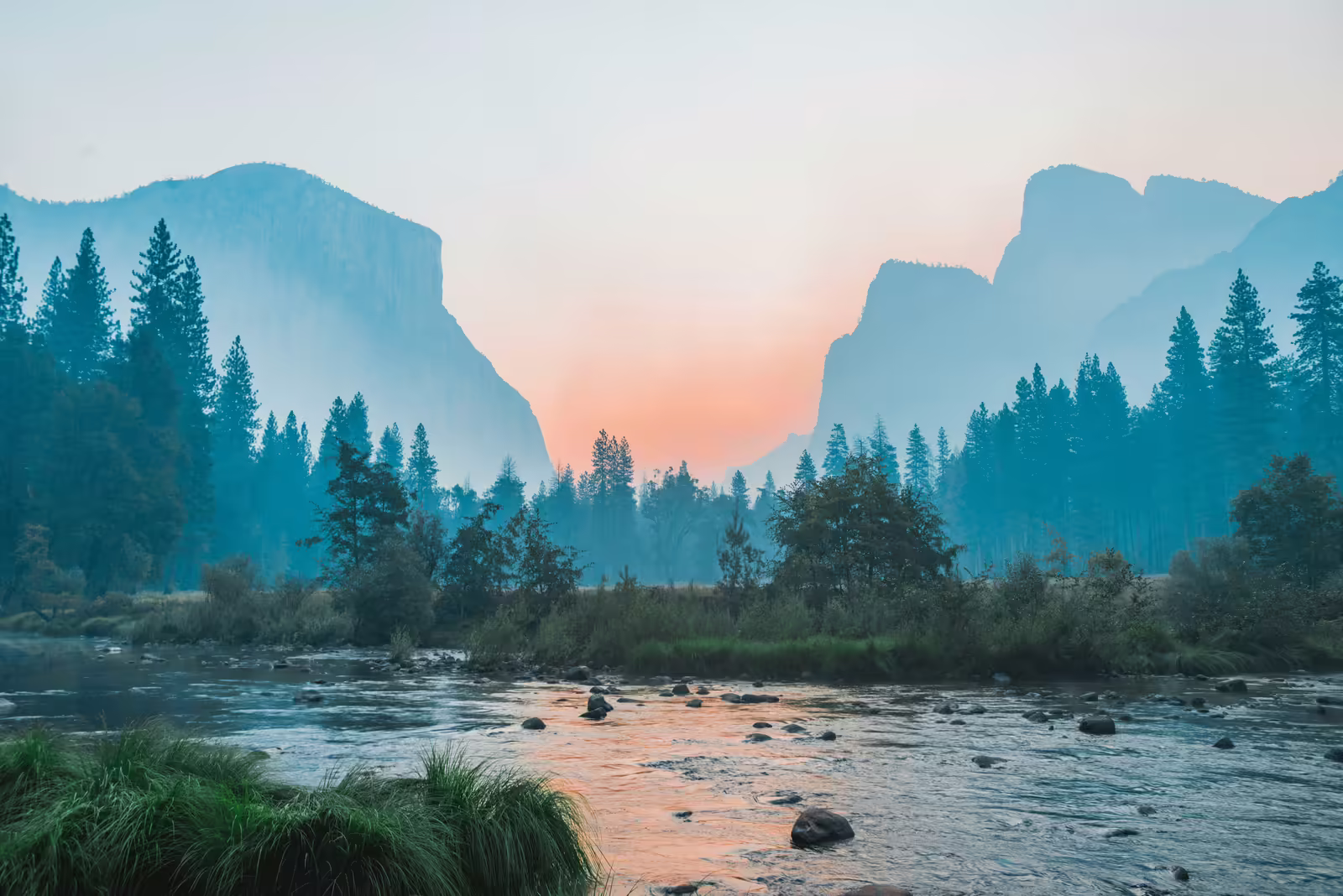 Fluss in einem Bergtal bei Sonnenaufgang