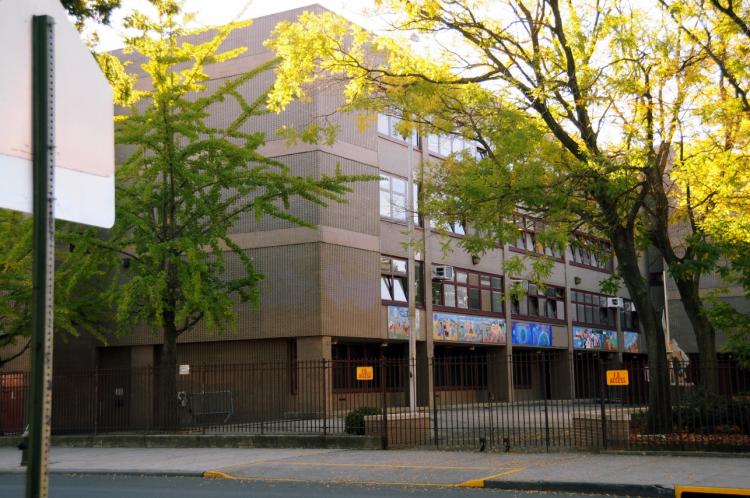 Exterior view of Bronx school building with colorful mural and trees