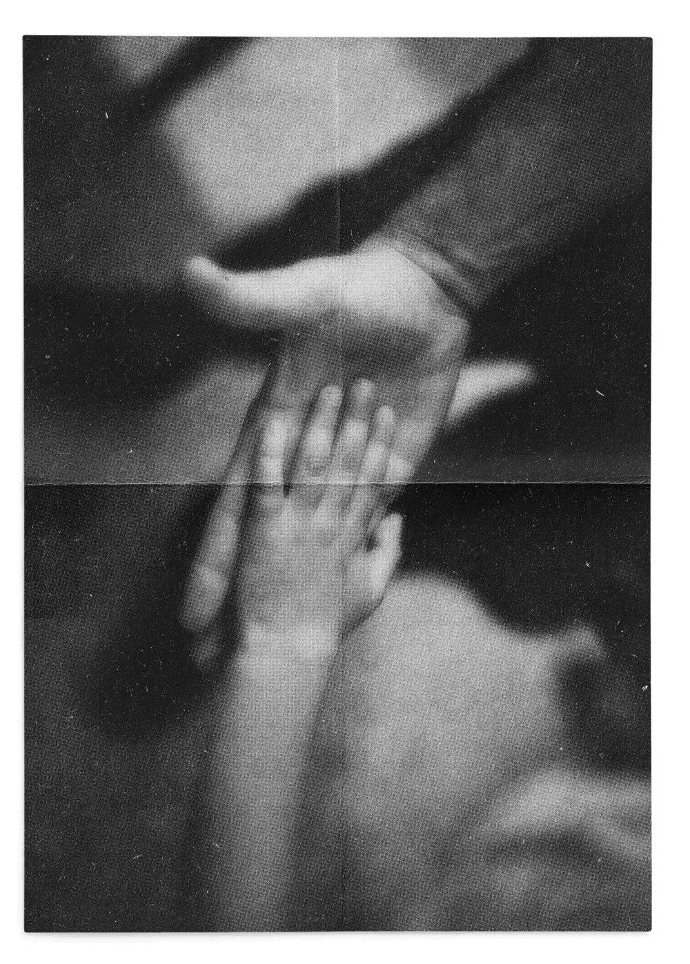 Black and white photo of an adult hand holding a child's hand.