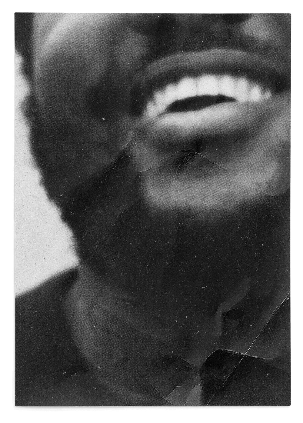 Close-up black and white photo of a man smiling.