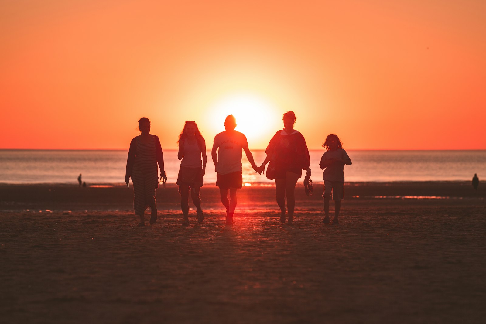 Family walking along the beach at golden hour