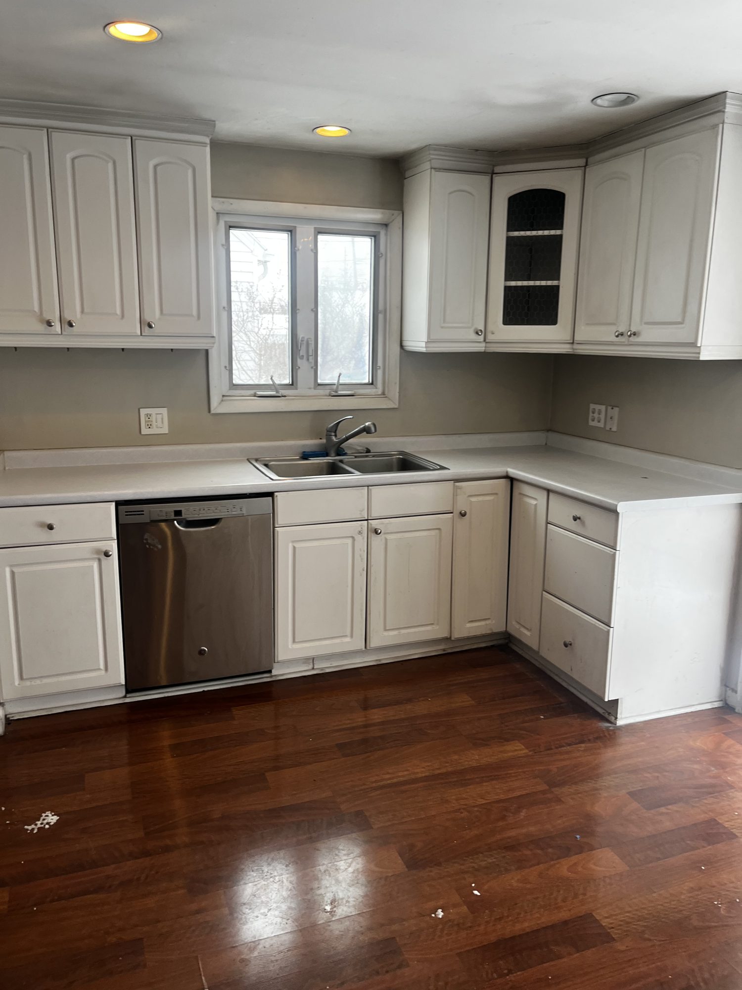 The Cheektowaga kitchen before the remodel: dated cabinets countertops, and faucet.