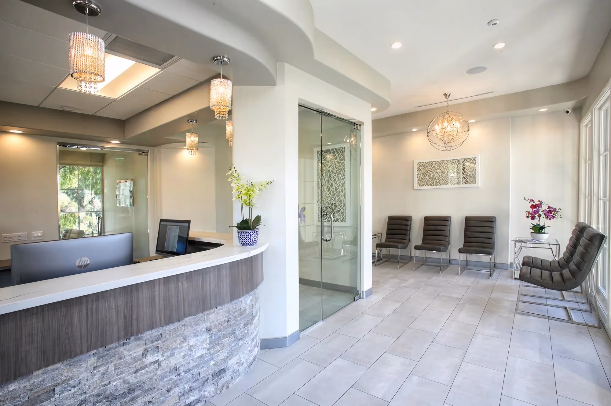 Wide view of Ortega Cottage Dentistry reception desk, waiting area, and glass consultation room with crystal lighting