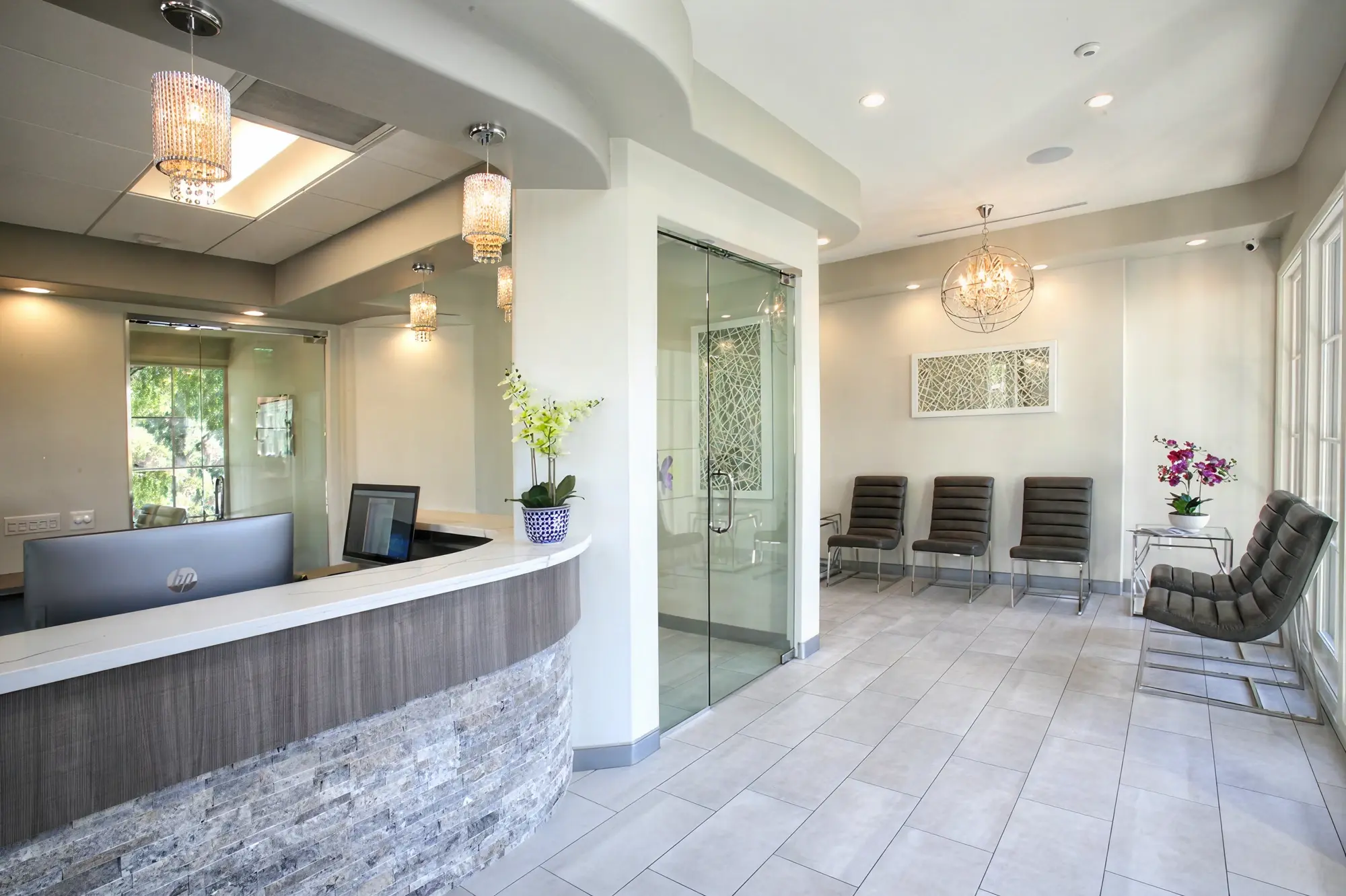 Wide view of Ortega Cottage Dentistry reception desk, waiting area, and glass consultation room with crystal lighting