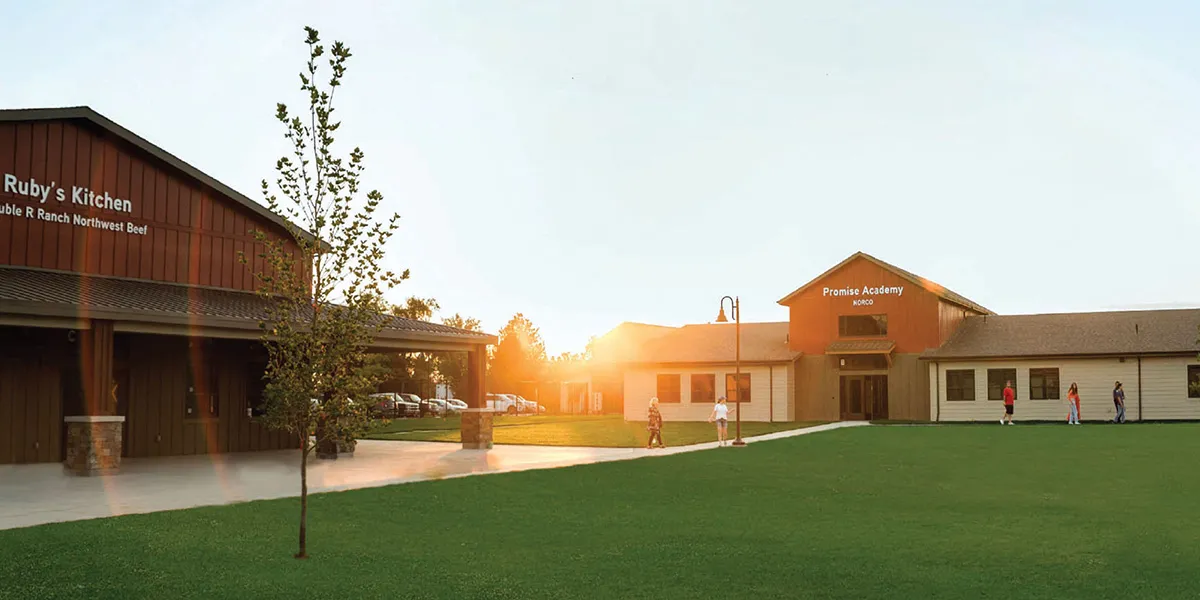 Sunset view of the campus green with Ruby's Kitchen and Promise Academy buildings