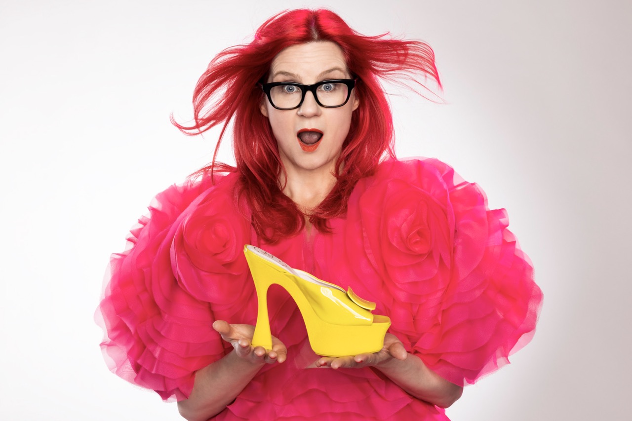 Glynis Traill-Nash photographed for In These Shoes, holding a yellow high-heeled shoe.
