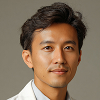 Portrait of a young man with dark hair and a slight smile wearing a light-colored shirt and jacket against a neutral background.